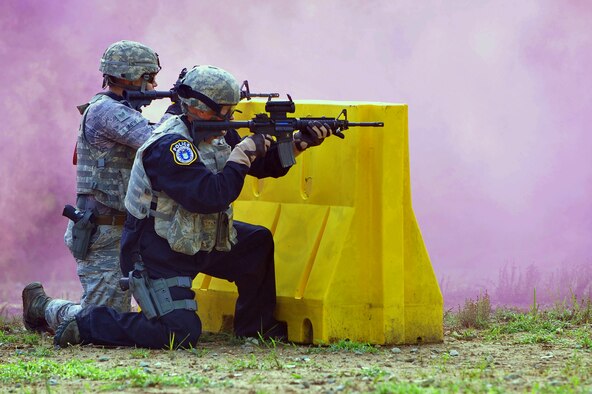 Chief Master Sgt. Frank Batten, right, Ninth Air Force command chief, and Staff Sgt. Ronald Smith, 4th Security Forces Squadron flight sergeant, return simulated rounds of fire during a training exercise at Seymour Johnson Air Force Base, North Carolina, June 19, 2015. Batten reviewed the installation’s combat readiness and daily operations during his visit. (U.S. Air Force photo by Senior Airman John Nieves Camacho/Released)
