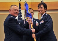Lt. Col. Courtney Finkbeiner, right, accepts command of the 341st Medical Operations Squadron from Col. Christopher Phillips, 341st Medical Group commander, left, June 23 at the Grizzly Bend. Guidon bearer Master Sgt. Ty Zabel, 341st MDOS superintendent, center, looks on. (U.S. Air Force photo/John Turner)