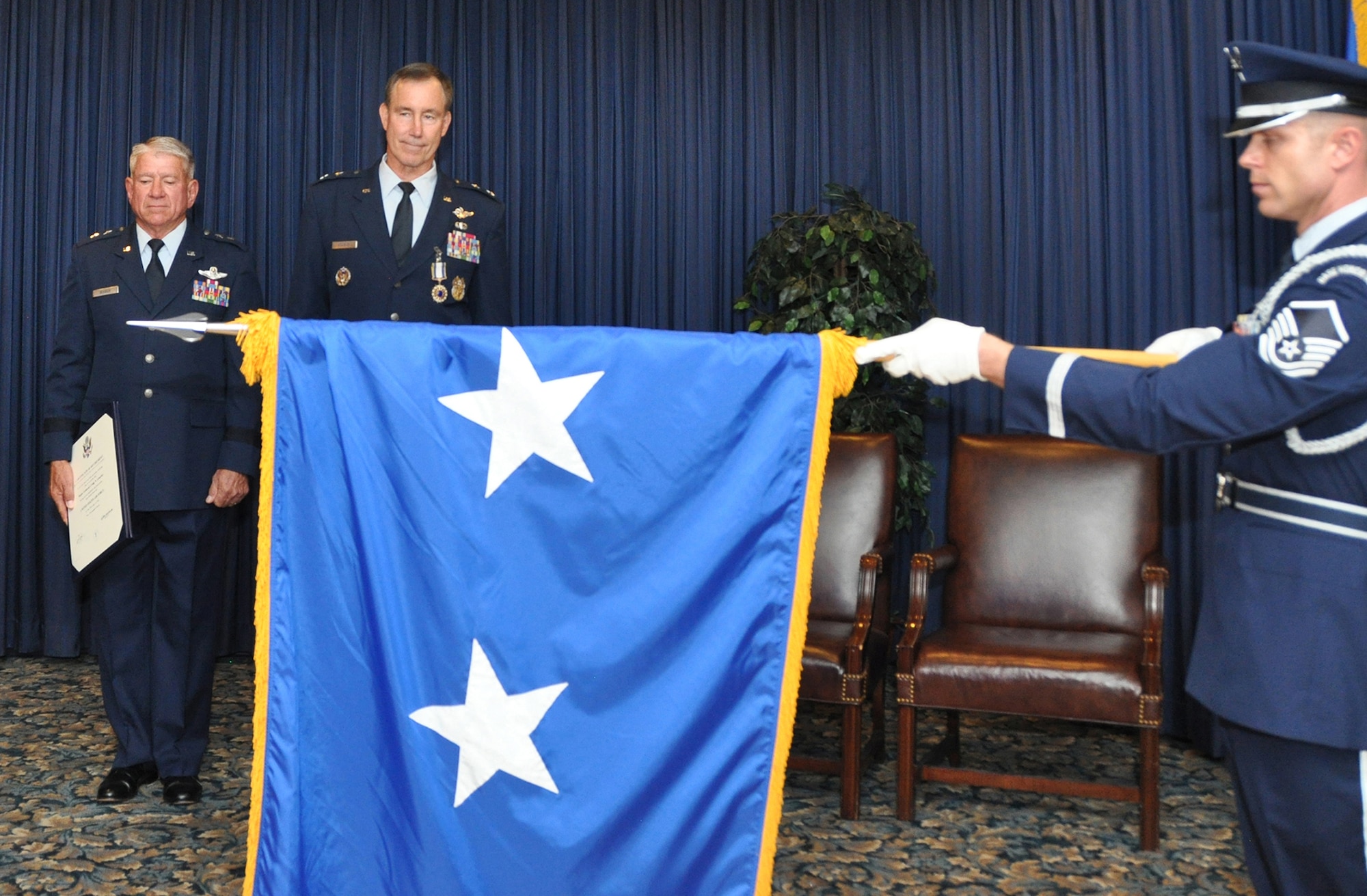 Maj. Gen. Craig Gourley (center) watches as Master Sgt. Todd Ryan, 301st Fighter Wing Honor Guard, furls his personal colors June 5 during his retirement ceremony at the Naval Air Station Fort Worth Joint Reserve Base, Texas. Maj. Gen. (ret) James Sluder (left), long time friend and comrade-in-arms, was presiding officer over the ceremony. (U.S. Air Force photo by Master Sgt. Julie Briden-Garcia)