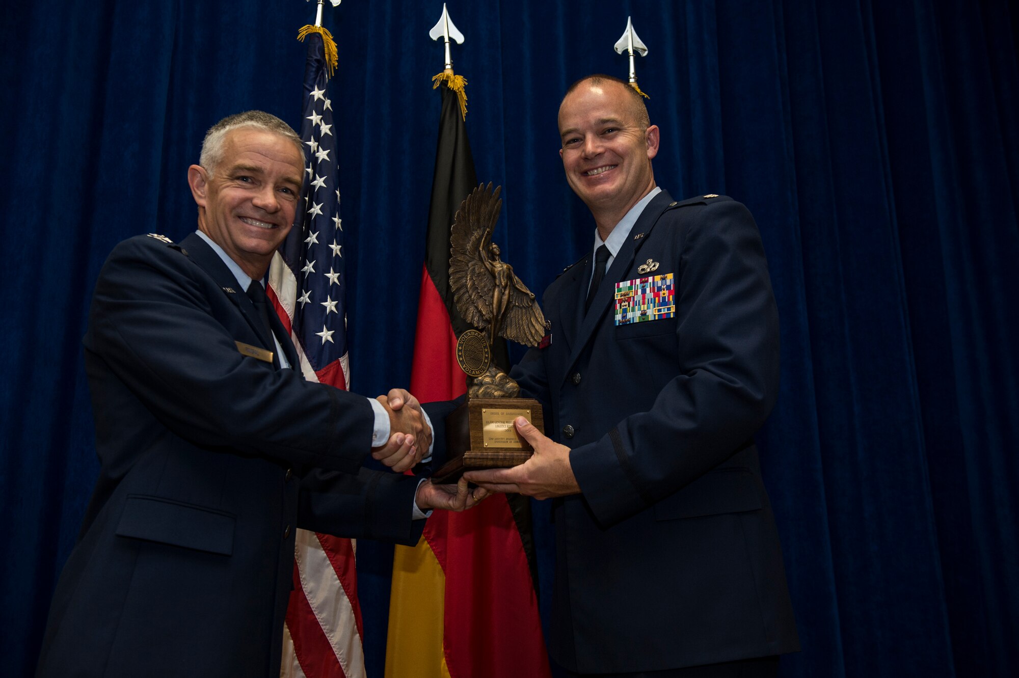 U.S. Air Force Col. Tod R. Fingal, U.S. Air Forces in Europe and Air Forces Africa deputy of operations, presents the Maj. Gen. Warren R. Carter trophy to U.S. Air Force Lt. Col. Phillip Noltemeyer, 52nd Logistics Readiness Squadron commander, during an award presentation at the Brick House on Spangdahlem Air Base, Germany, June 24, 2015. The 52nd LRS received the trophy for winning the 2014 Daedalian Logistics Readiness Award out of all logistic readiness squadrons in the U.S. Air Force. (U.S. Air Force photo by Staff Sgt. Christopher Ruano/Released)