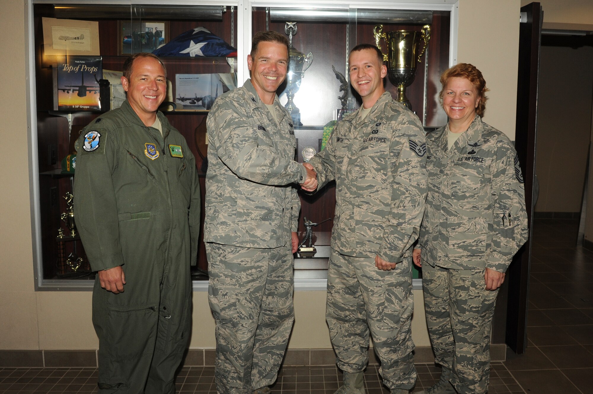 Lt. Col. Jason Kuhns, 61st Airlift Sqadron acting commander (far left) along with Col. Charles Brown, 19th Airlift Wing commander (left) and Chief Master Sgt. Rhonda Buening (far right) congratulate Staff Sgt. Nathan Smith, 61st AS squadron aviation resource management assistant non-commissioned officer in-charge (right), for his selection as Combat Airlifter of the week June 22, 2015, at Little Rock Air Force Base, Ark. Smith maintained accountability of flight and ground training records for more than 450 aircrew members throughout his three-year tour at Little Rock AFB. (U.S. Air Force photo by Senior Airman Scott Poe)