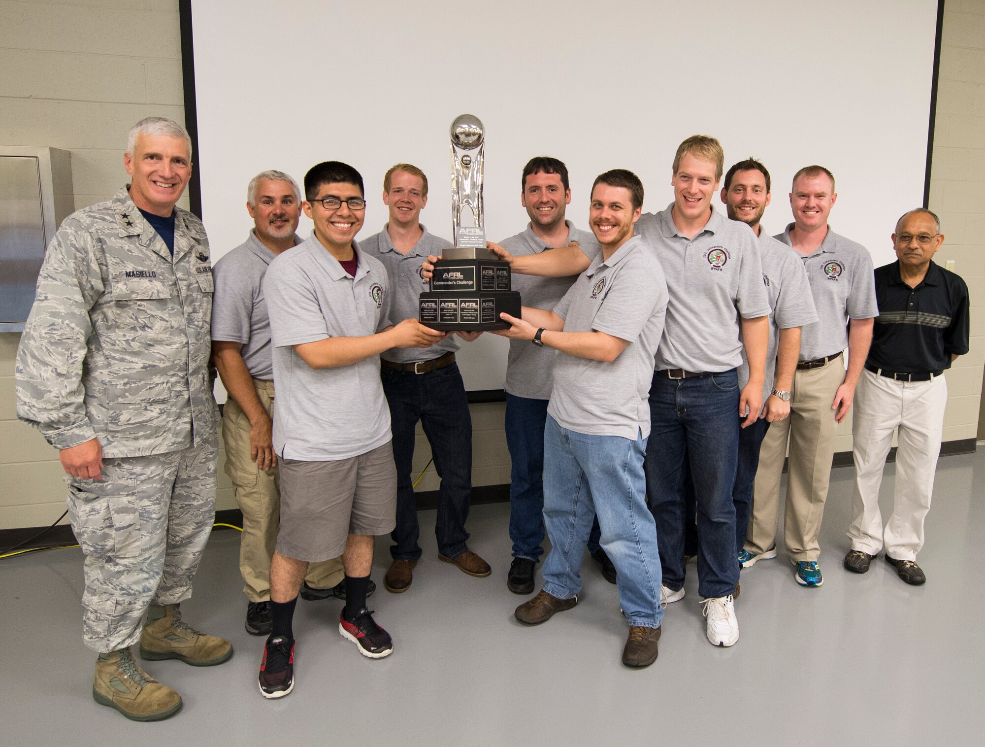 Maj. Gen. Thomas J. Masiello, Air Force Research Laboratory commander, presents the team from Wright-Patterson Air Force Base, Ohio, the 2015 AFRL Commanders Challenge Trophy after they were named the winners, June 19, at the Muscatatuck Urban Training Center, Butlerville,, Ind. The challenge involved four teams from Wright-Patterson Air Force Base, Ohio, Robbins AFB,Ga., Hill AFB, Utah and Kirtland AFB, N.M., who were given the task to develop systems for detecting an active shooter. (U.S. Air Force photo by Wesley Farnsworth)