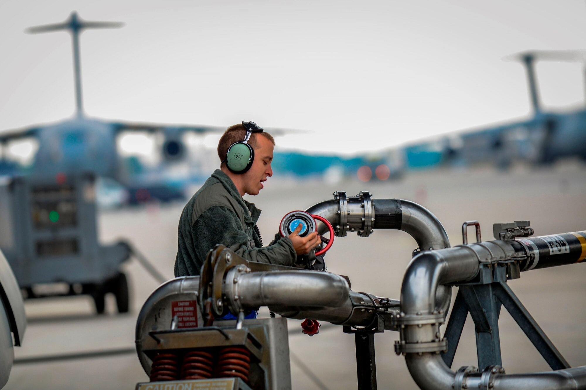 Staff Sgt. Adam Hart, 721st Aircraft Maintenance Squadron electrical and environmental systems specialist, disconnects a refueling pump from a C-17 Globemaster III before a flight to Bulgaria June 20, 2015, Ramstein Air Base, Germany.  Airmen and Soldiers worked together to load two M1A2 Abrams main battle tanks onto the aircraft over a span of two days. (U.S. Air Force photo/Senior Airman Nicole Sikorski) 