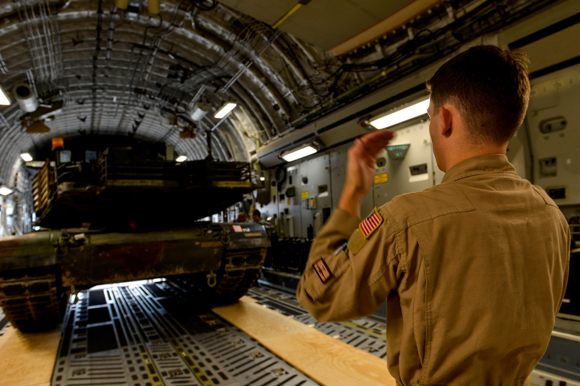 Airman 1st Class Kenneth Whitler, 7th Airlift Squadron aircraft loadmaster, from Joint Base Lewis-McChord, Washington, directs an M1A2 Abrams main battle tank onto a  C-17 Globemaster III June 20, 2015, Ramstein Air Base, Germany.  Airmen and Soldiers from across the U.S. European Command theater worked together to transport two tanks weighing 170 tons total to Bulgaria to participate in multinational training in support of Operation Atlantic Resolve training. (U.S. Air Force photo/Senior Airman Nicole Sikorski)