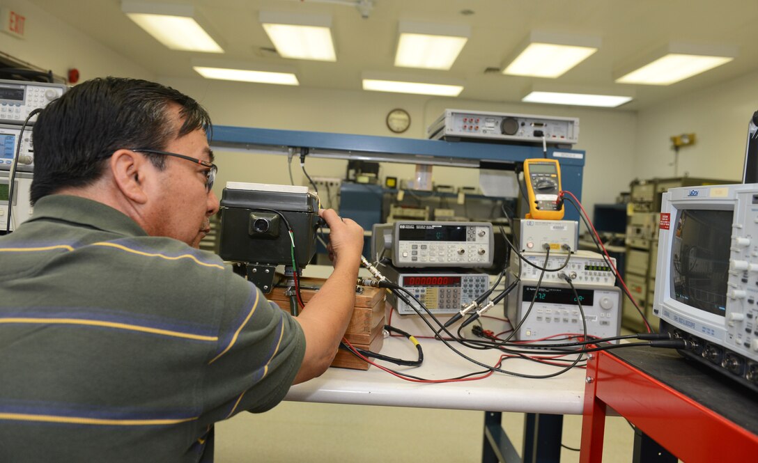 Oscar Cabatic, 36th Maintenance Squadron Precision Measurement Equipment Laboratory technician, analyzes a signal using a transponder test set, a spectrum analyzer, and a peak power meter June 19, 2015, at Andersen Air Force Base, Guam.  PMEL technicians ensure all the equipment they calibrate on a daily basis is accurate and reliable for the many units they support. (U.S. Air Force photo by Airman 1st Class Arielle Vasquez/Released)