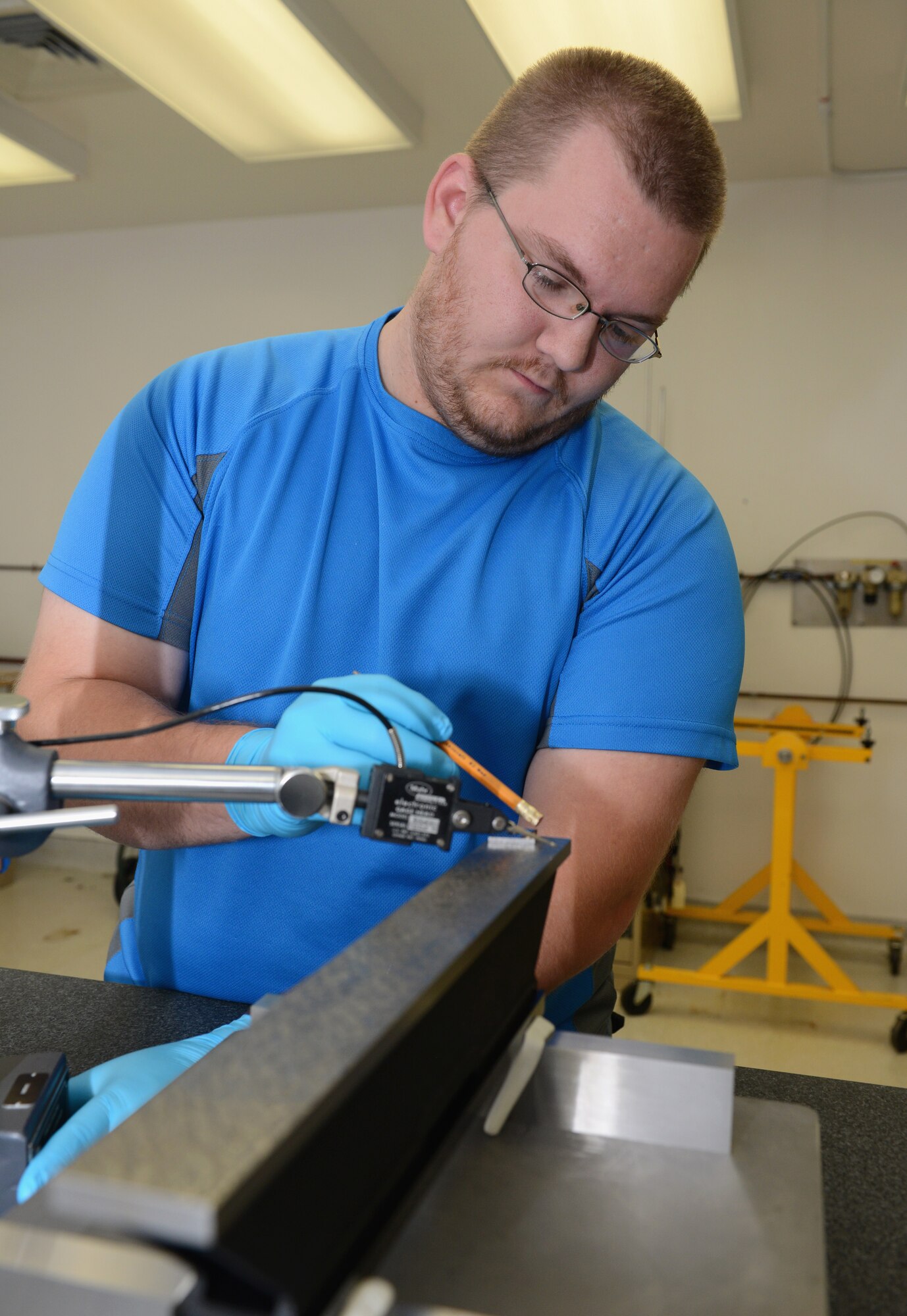 Elijah Bacchus, 36th Maintenance Squadron Precision Measurement Equipment Laboratory technician, calibrates the flatness of the base of a master level June 19, 2015, at Andersen Air Force Base, Guam. PMEL technicians calibrate anything from scales, digital voltmeters and generators to provide reliable equipment for the units they support.  (U.S. Air Force photo by Airman 1st Class Arielle Vasquez/Released)