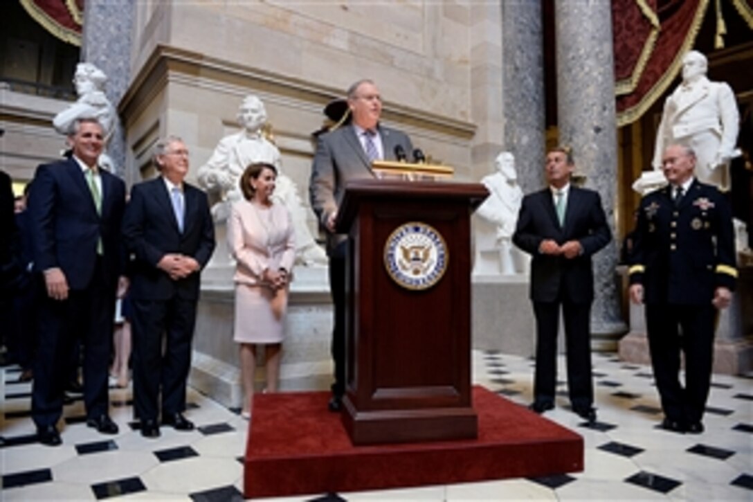 Deputy Defense Secretary Bob Work delivers remarks during a recognition ceremony for the 2015 Department of Defense Warrior Games at the U.S. Capitol as Army Gen. Martin E. Dempsey, right, chairman of the Joint Chiefs of Staff, and congressional leaders look on, June 24, 2015.