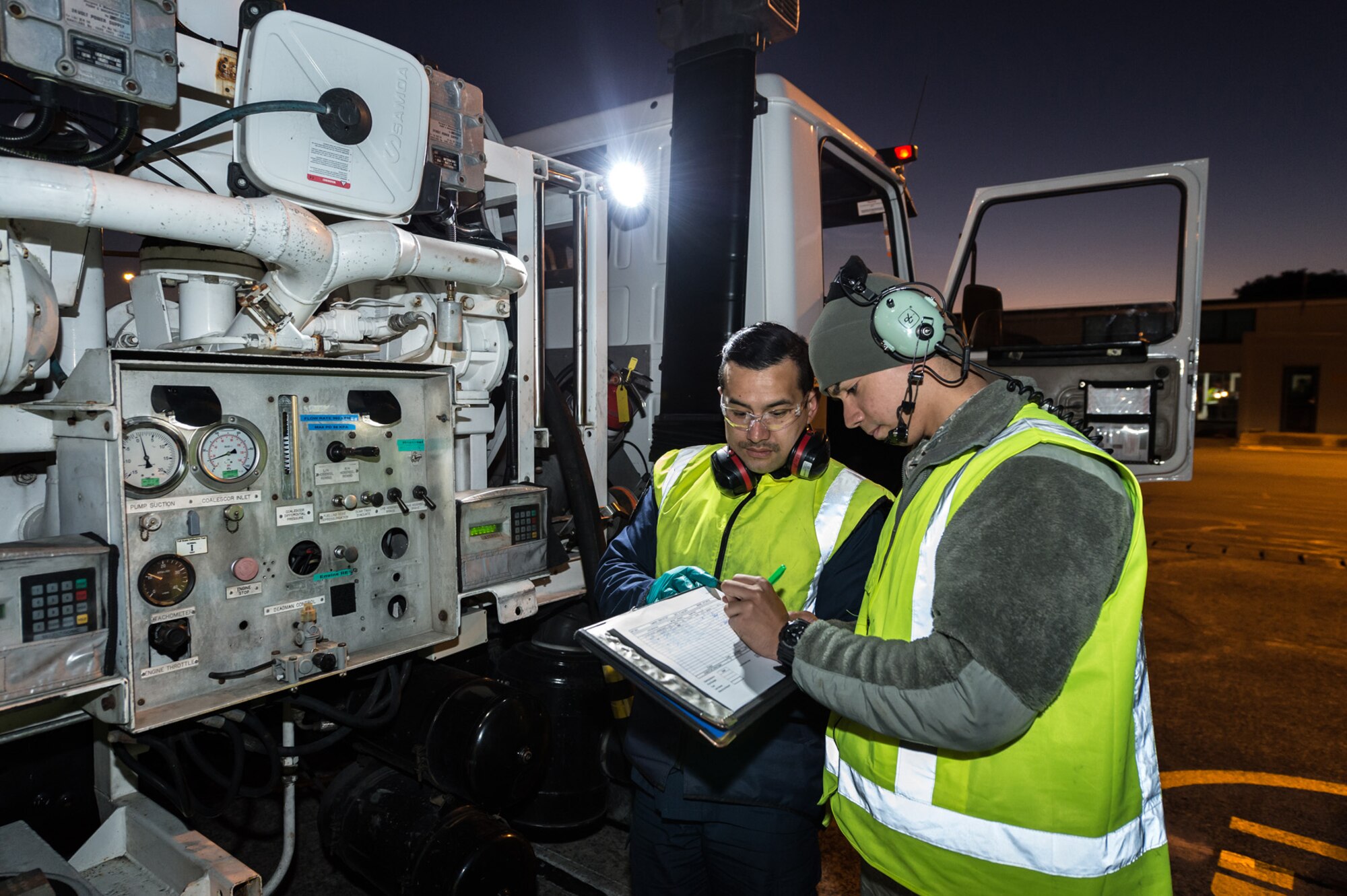 Royal New Zealand Air Force Aviation Refueler LAC Kennedy Howard (left) completes paperwork with U.S. Air Force Senior Airman Luke-Nathan De Jesus, (right) 353rd Special Operations Maintenance Squadron, after refueling a 1st Special Operations Squadron MC-130H Combat Talon II aircraft on the flight line June 16, 2015 at RNZAF Base Auckland, New Zealand.  Members from the 353rd Special Operations Group and the Royal New Zealand Air Force and Army are participating in Exercise Flash Lantern Net June 18-27 at RNZAF Base Auckland in New Zealand. (New Zealand Defense Force photo by Roderick Mackenzie\Released)
