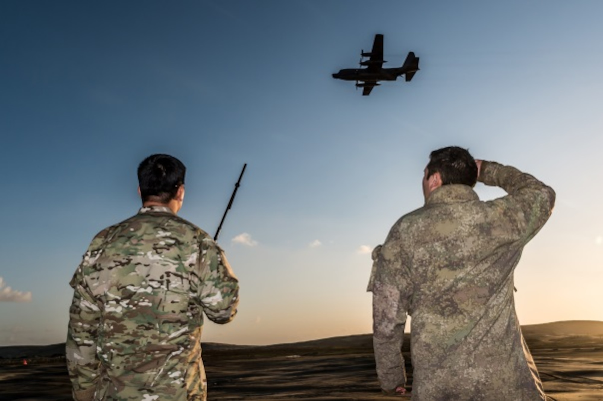 U.S. Air Force Master Sgt. Matthew Packer (left), 353rd Special Operations Support Squadron, and New Zealand Army Private Te Karanga-o-te-tui Marino (right) watch as an MC-130H Combat Talon II, from the 1st Special Operations Squadron conducts an air drop June 22, 2015 at a Drop Zone in Kaipara, New Zealand, during Exercise Flash Lantern Net.  Members from the 353rd Special Operations Group and the Royal New Zealand Air Force and Army participating in Exercise Flash Lantern Net June 18-27 at Royal New Zealand Air Force Base Auckland in New Zealand.(New Zealand Defense Force photo by Roderick Mackenzie)
