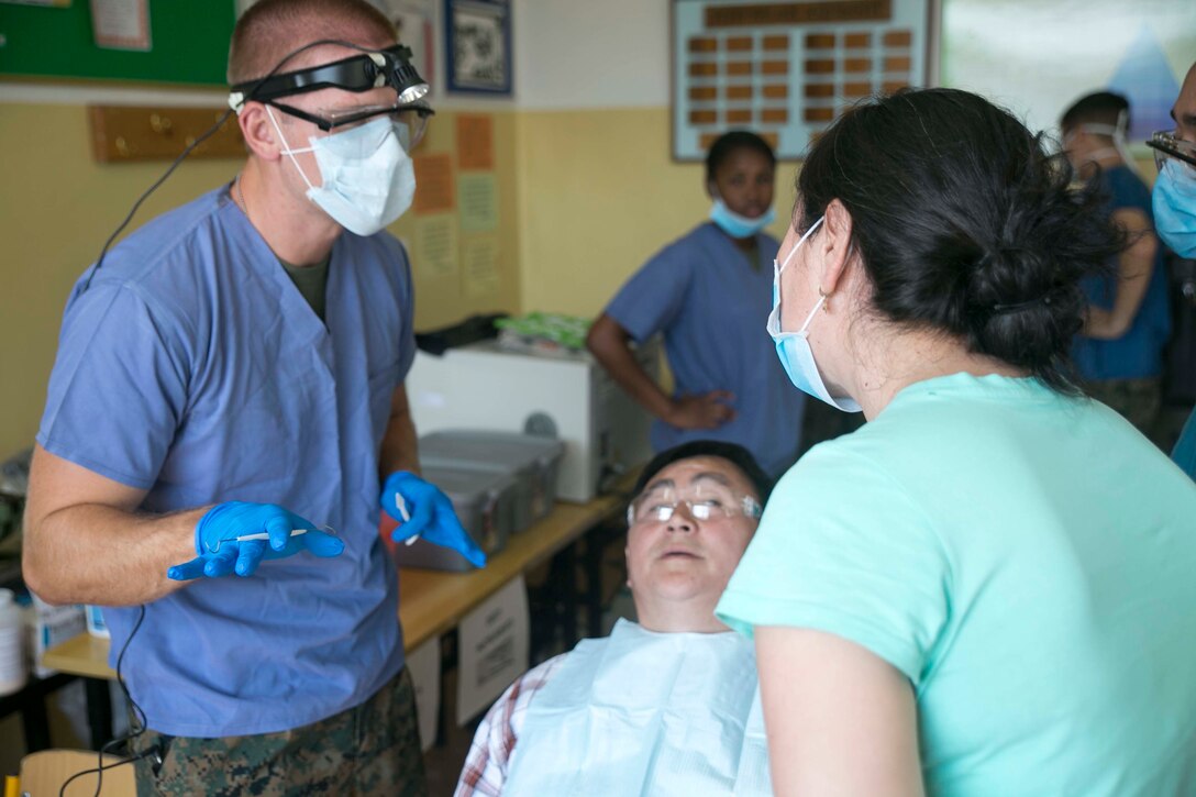 U.S. Navy Lt. Phillip Jakubowicz, left, speaks to a Mongolian interpreter about dental procedures he will perform on the Mongolian patient as part of the health services support engagement during Khaan Quest 2015 at the 79th High School in Ulaanbaatar, Mongolia, June 21. Khaan Quest is a regularly scheduled, multinational exercise hosted annually by the Mongolian Armed Forces and co-sponsored by U.S. Army, Pacific, and U.S. Marine Corps Forces, Pacific. Jakubowicz is a dental officer with 3rd Dental Battalion, 3rd Marine Logistics Group, III Marine Expeditionary Force. 
