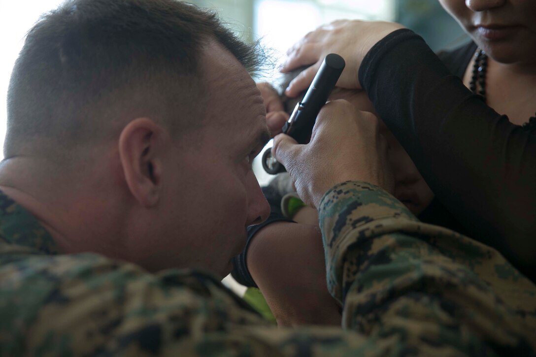 U.S. Navy Lt. Cmdr. James Hartwell, left, provides medical care to a Mongolian child as part of the Health Services Support Engagement during Khaan Quest 2015 at the 79th High School in Ulaanbaatar, Mongolia, June 21. Khaan Quest is a regularly scheduled, multinational exercise hosted annually by the Mongolian Armed Forces and co-sponsored by U.S. Army, Pacific, and U.S. Marine Corps Forces, Pacific. Hartwell is a medical officer with 3rd Medical Battalion, 3rd Marine Logistics Group, III Marine Expeditionary Force. 