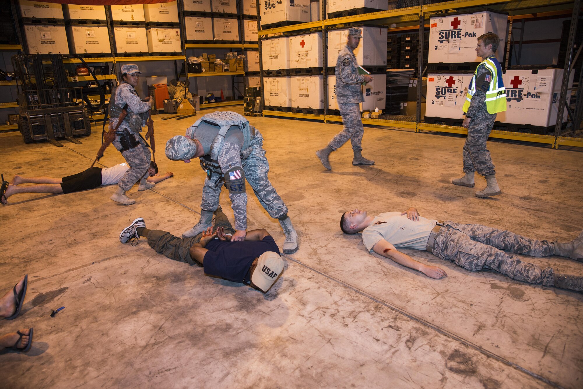 Members of the 379th Expeditionary Security Forces Squadron are evaluated while working to clear a medical warehouse facility during an active shooter scenario June 19, 2015, at Al Udeid Air Base, Qatar. Several agencies on base were tested on their reactions to the scenario to make sure proper protocols were followed in case an on-base incident truly ever occurred.  (U.S. Air Force photo by Tech. Sgt. Rasheen Douglas)