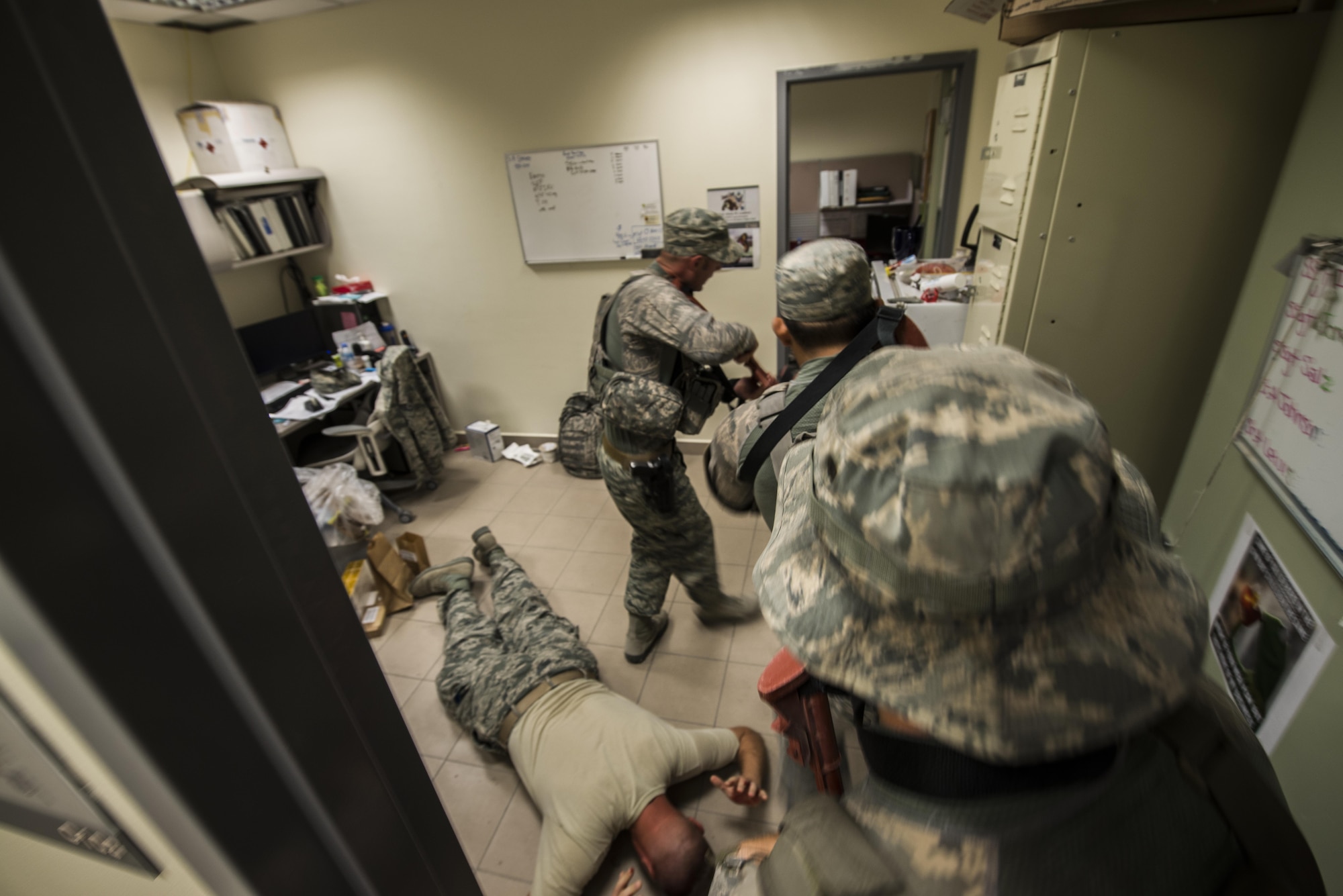 Members of the 379th Expeditionary Security Forces Squadron apprehend a member while clearing out a room searching for any possible threats during an active shooter scenario at a medical warehouse facility June 19, 2015, at Al Udeid Air Base, Qatar. Several agencies on base were tested on their reactions to the scenario to make sure proper protocols were followed in case an on-base incident truly ever occurred. (U.S. Air Force photo by Tech. Sgt. Rasheen Douglas)