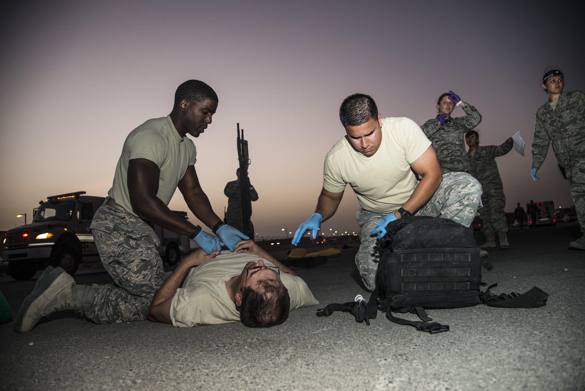 U.S. Air Force Staff Sgts. Robert McClintok and Jose Leiva simulate performing life-saving procedures on a patient June 19, 2015, during an active shooter scenario at Al Udeid Air Base, Qatar. Both Airmen are emergency medical technicians assigned to the 379th Expeditionary Medical Operations Squadron. The active shooter scenario took place testing several agencies on base to evaluate their reactions to the scenario to make sure proper protocols were followed in case an on-base incident truly ever occurred.   (U.S. Air Force photo by Tech. Sgt. Rasheen Douglas)