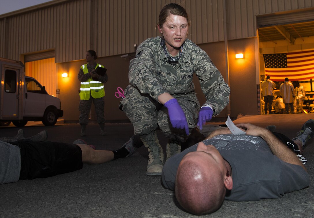 U.S. Air Force Staff Sgt. Sarah Shipman, 379th Expeditionary Medical Operations Squadron emergency medical technician, asks a patient his symptoms to properly give him care during an active shooter scenario June 19, 2015, at Al Udeid Air Base, Qatar. Several agencies on base were tested on their reactions to the scenario to make sure proper protocols were followed in case an on-base incident truly ever occurred. (U.S. Air Force photo by Tech. Sgt. Rasheen Douglas)
