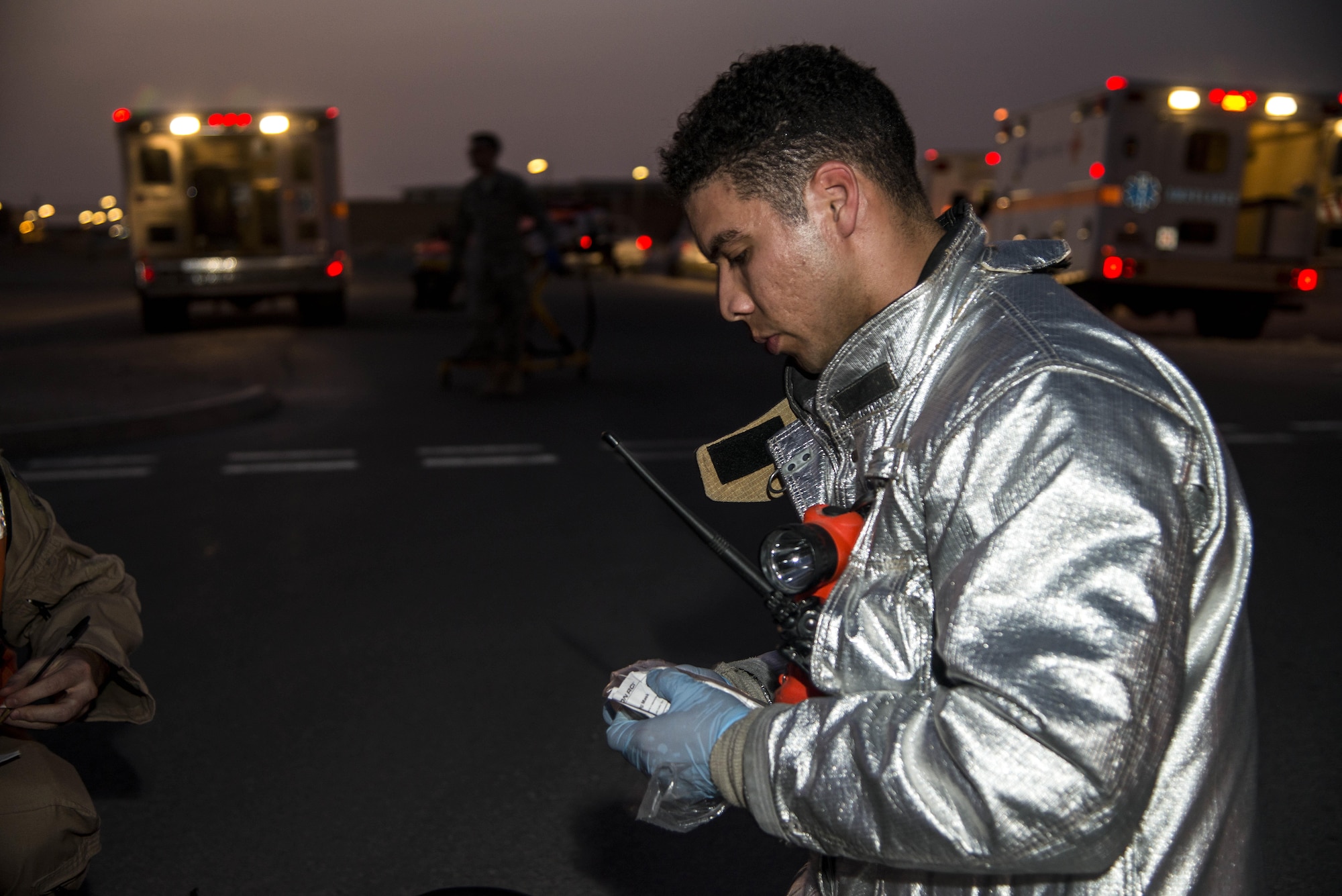 U.S. Air Force Staff Sgt. Ramon Betancourt, 379th Expeditionary Civil Engineer Squadron firefighter, pulls out a mask to prep a simulated patient to be placed in an ambulance during an active shooter scenario June 19, 2015, at Al Udeid Air Base, Qatar. Several agencies on base were tested on their reactions to the scenario to make sure proper protocols were followed in case an on-base incident truly ever occurred. (U.S. Air Force photo by Tech. Sgt. Rasheen Douglas)