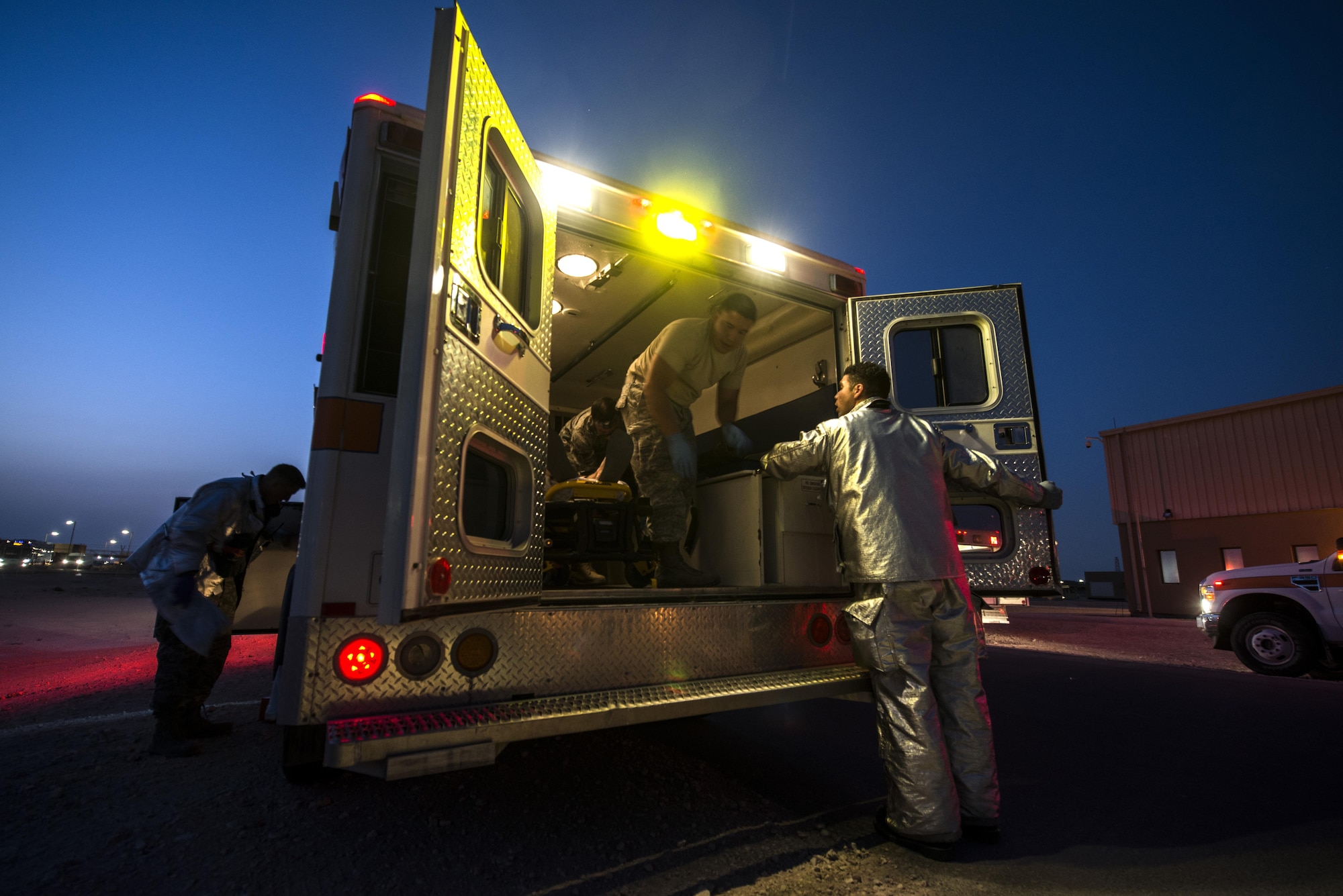 U.S. Air Force Staff Sgt. Ramon Betancourt, 379th Expeditionary Civil Engineer Squadron firefighter, talks to emergency medical technicians from the 379th Expeditionary Medical Operations Squadron about the moving of patients during an active shooter scenario June 19, 2015, at Al Udeid Air Base, Qatar. Several agencies on base were tested on their reactions to the scenario to make sure proper protocols were followed in case an on-base incident truly ever occurred. (U.S. Air Force photo by Tech. Sgt. Rasheen Douglas)