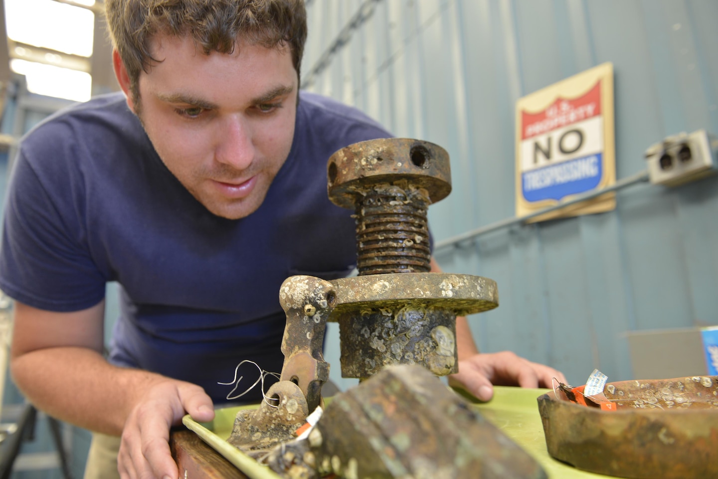 Elevator screw: Parker Brooks, a conservator and graduate student from Texas A&M University’s Conservation Research Laboratory, examines an elevator screw (right) and firing mechanism from a cannon. In the foreground are a sabot (right) and rear gun sight for a 32-pound rifle cannon. The elevator screw was used to change the height of the cannon.