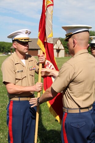 Maj. Geoffry M. Hollopeter passes the Marine Corps Colors to Maj. John P. Harley to signify the change of command for Recruiting Station Indianapolis at Fort Harrison State Park, Indianapolis June 24, 2015.