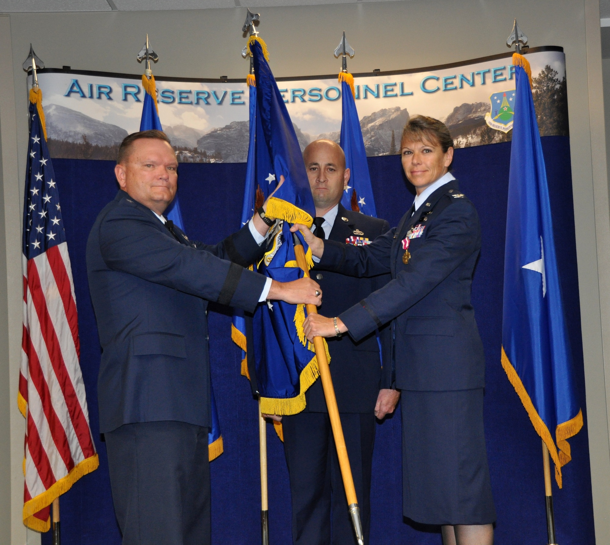 Brig. Gen. Samuel "Bo" Mahaney, Air Reserve Personnel Center commander, hands the Headquarters Individual Reservist Readiness and Integration Organization flag to Col. Carolyn Stickell, incoming HQ RIO commander, as Master Sgt. Jerrod Kester, HQ RIO first sergeant, stands by during an assumption of command ceremony held June 24, 2015, on Buckley Air Force Base, Colo. Stickell replaced outgoing HQ RIO commander Col. Christopher Cronce, following his move to the Pentagon, where he is now the deputy director for Reserve Personnel. Stickell became the second commander of HQ RIO since its activation Oct. 28, 2014. (U.S. Air Force photo/Tech. Sgt. Rob Hazelett)