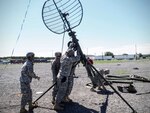 New York Army National Guard Soldiers of the 42nd Infantry Signal Company hammer in the supports for a communications tower with the assistance of Staff Sgt. Delores Gordon of the 10th Mountain Division. The tower was part of annual training June 17, 2015, at Fort Drum, New York.