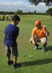 Billy Houston (right), volunteer golf instructor, coaches a child attending the Randolph Oaks Golf Course Junior Golf Camp June 17 at Joint Base San Antonio-Randolph.