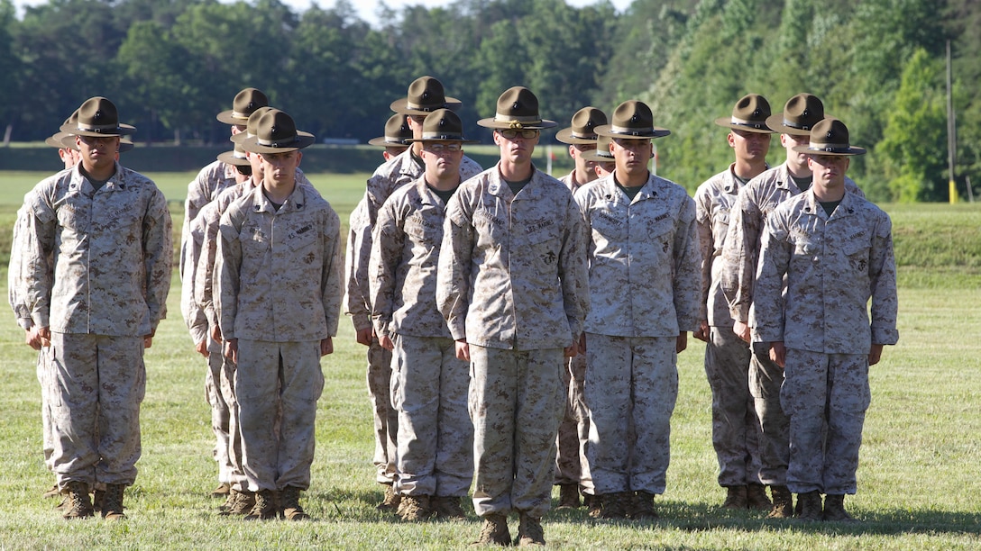 The Marine Corps Combat Shooting Team stands at attention during the opening ceremony of the 54th Interservice Rifle Championship at Marine Corps Base Quantico, Virginia, June 24, 2015. The matches were established in 1960 to promote the competition in arms program, which was established in 1901 to encourage interest and improvement in marksmanship by refining skills through advanced marksmanship training and competition. 