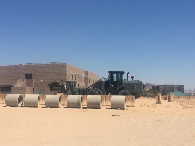 Cpl Betche, Mikyle a logistics specialist, helps to coordinate the movement of barriers to assist in the completion of the MCCES Tactical Training Facility. The facility will allow Marines within MCCES to utilize a vast amount of exercise equipment to maintain their physical standards.  