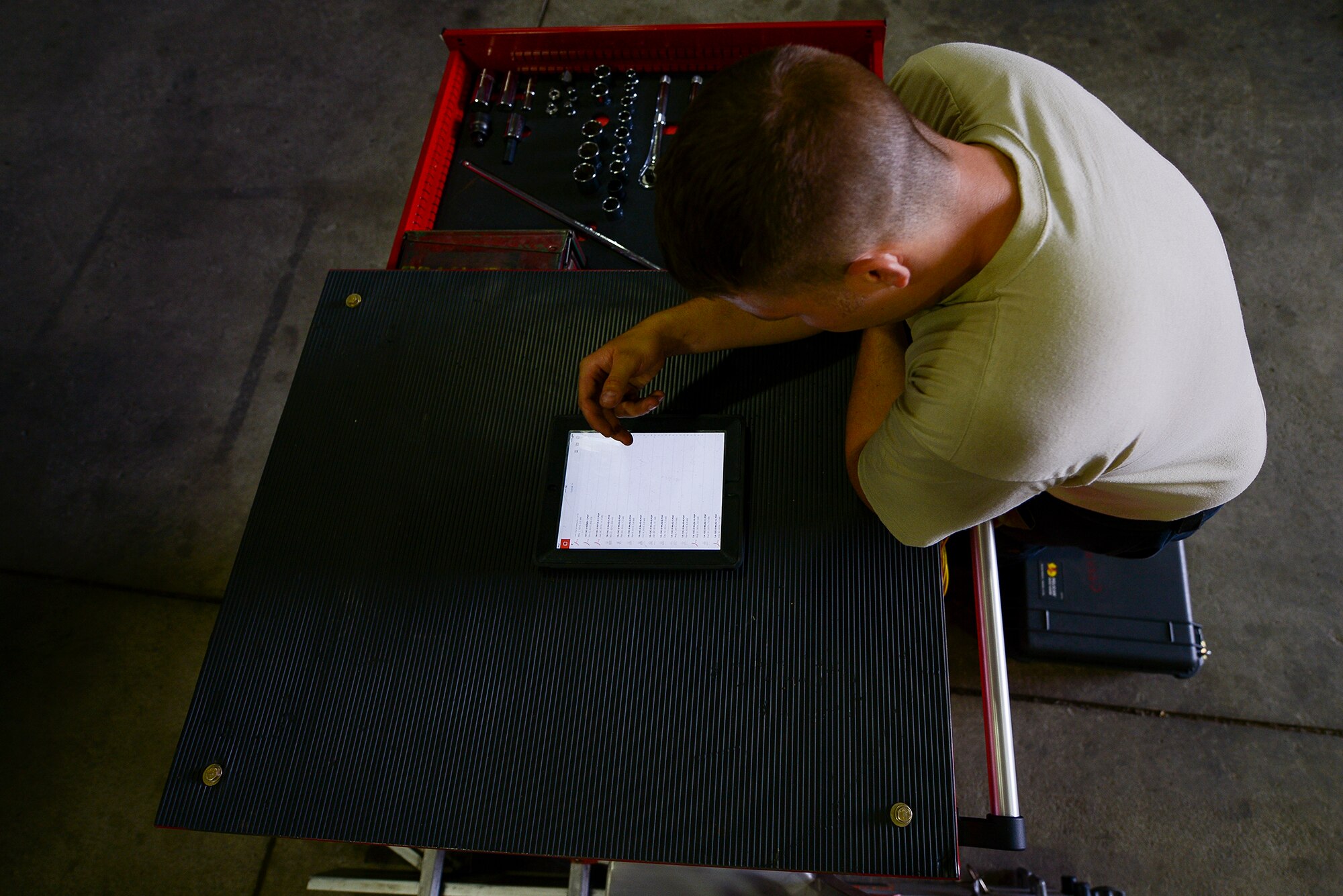 Staff Sgt. Christopher Simison, 25th Aircraft Maintenance Unit weapons load team chief, checks technical orders during a job June 22, 2015, at Osan Air Base, Republic of Korea. TOs are stored on wireless machines, allowing the crew to carry hundreds of pages worth of material on a small device.  (U.S. Air Force photo by Staff Sgt. Jake Barreiro/Released)