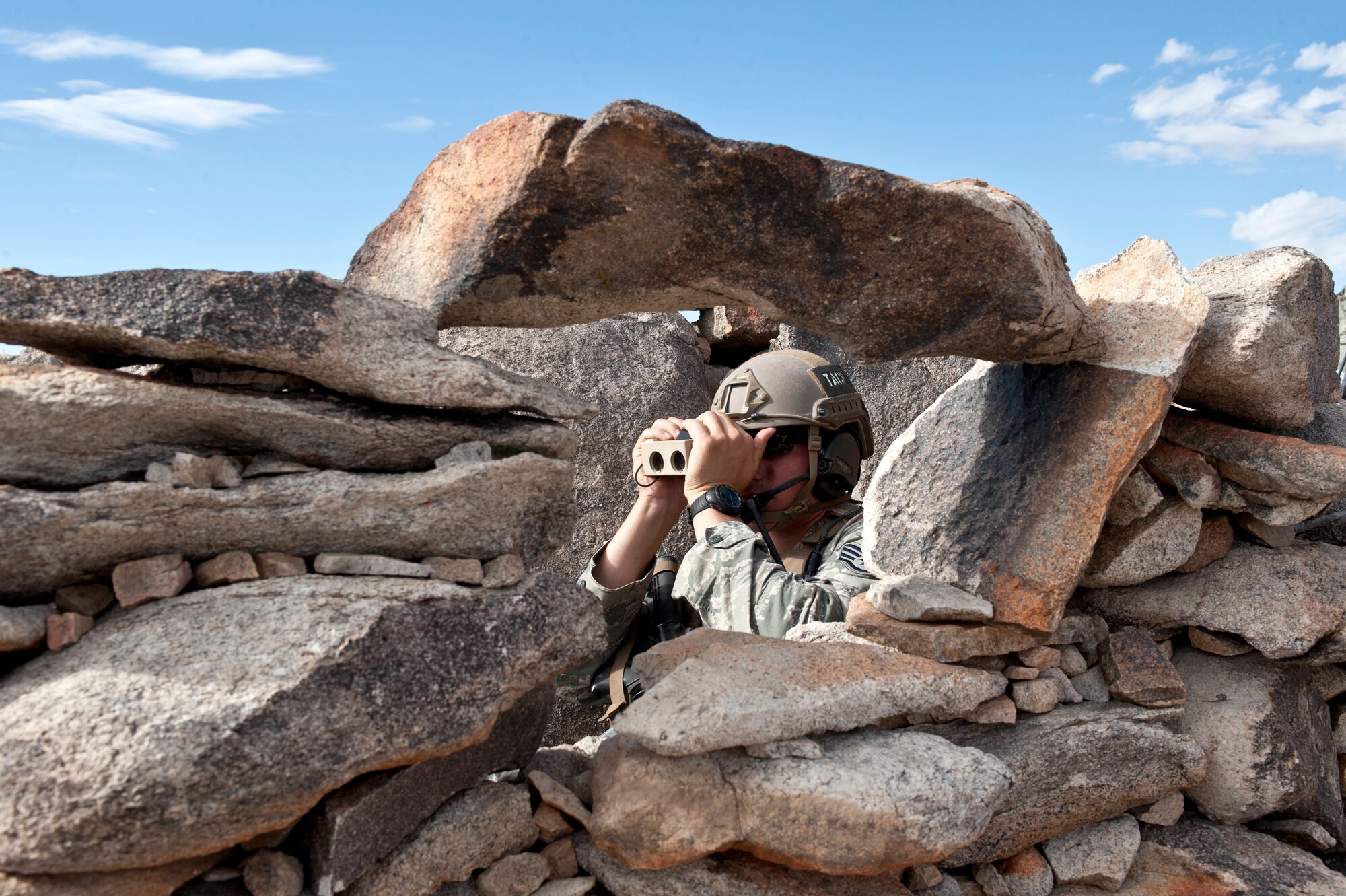 A tactical air control party Airman assigned to the 7th Air Support Operations Squadron, Fort Bliss, Texas, monitors radio communications between air and ground assets during a Green Flag 15-08 close air support training scenario at the National Training Center, Fort Irwin, Calif., June 12, 2015. TACP Airmen rely on realistic training methods to earn JTAC qualifications that authorize them to make calls for fire. (U.S. Air Force photo by Senior Airman Joshua Kleinholz)