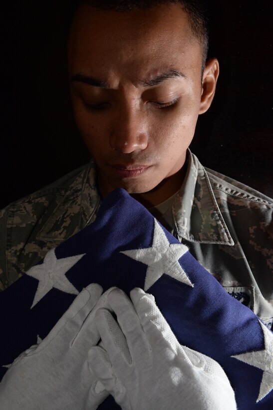 Senior Airman Alzen Amparo, a ceremonial guardsman from the 36th Civil Engineer Squadron, performs a dressing sequence during Andersen Blue Knights Honor Guard practice, June 24, 2015, at Andersen Air Force Base, Guam. The dressing sequence is performed to ensure the flag is folded properly before presenting it to the designated recipient. (U.S. Air Force photo by Senior Airman Amanda Morris/Released) 
