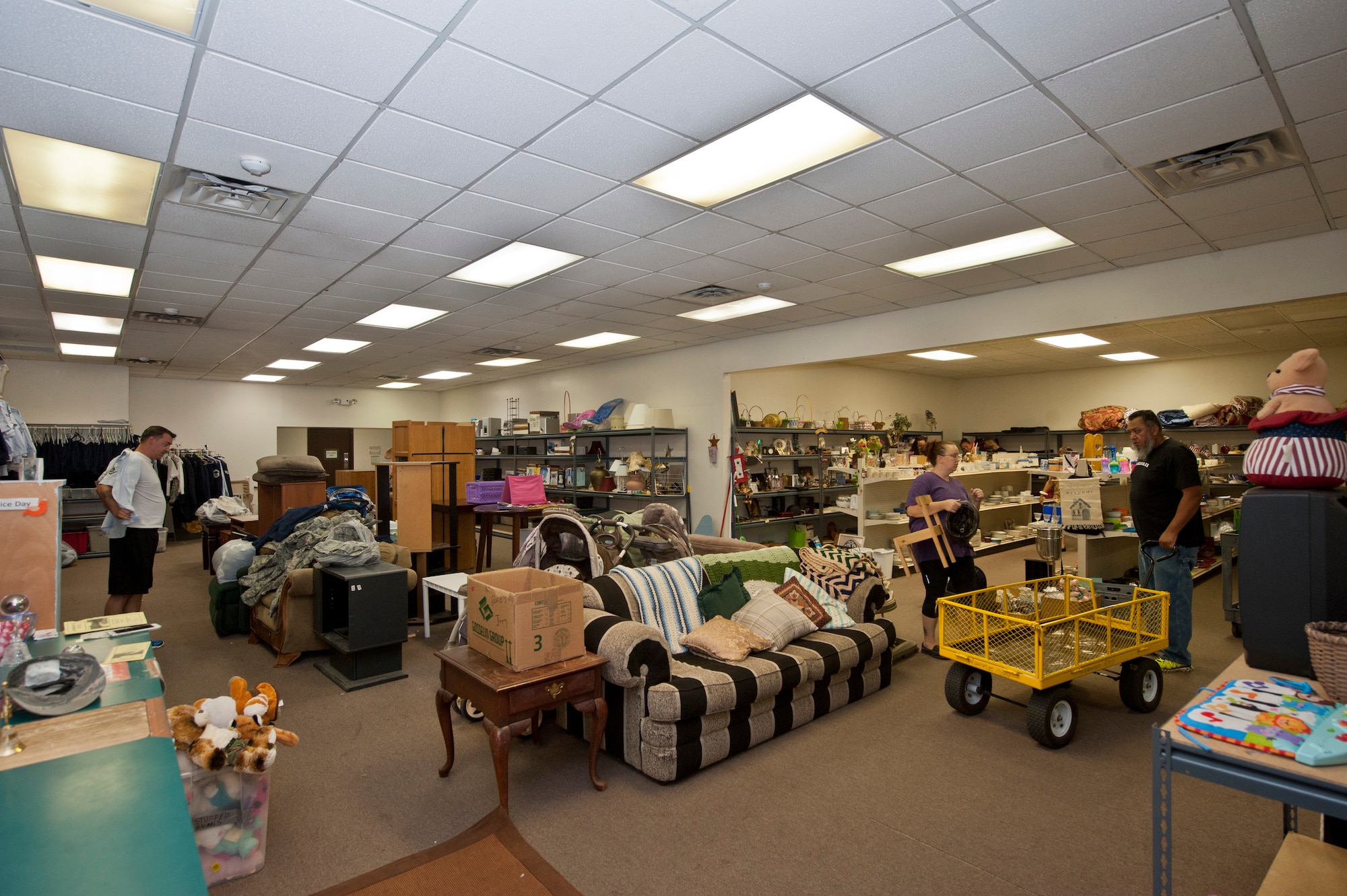 Patrons at the Airman’s Attic look through the store’s inventory on Nellis Air Force Base, Nev., June 18,2015. The Airman’s Attic is a volunteer-based organization where Airmen of all ranks can turn in or pick up military uniform items, and Airmen E-5 and below can score anything from a book to a TV; all for free. (U.S. Air Force photo by Airman 1st Class Jake Carter)