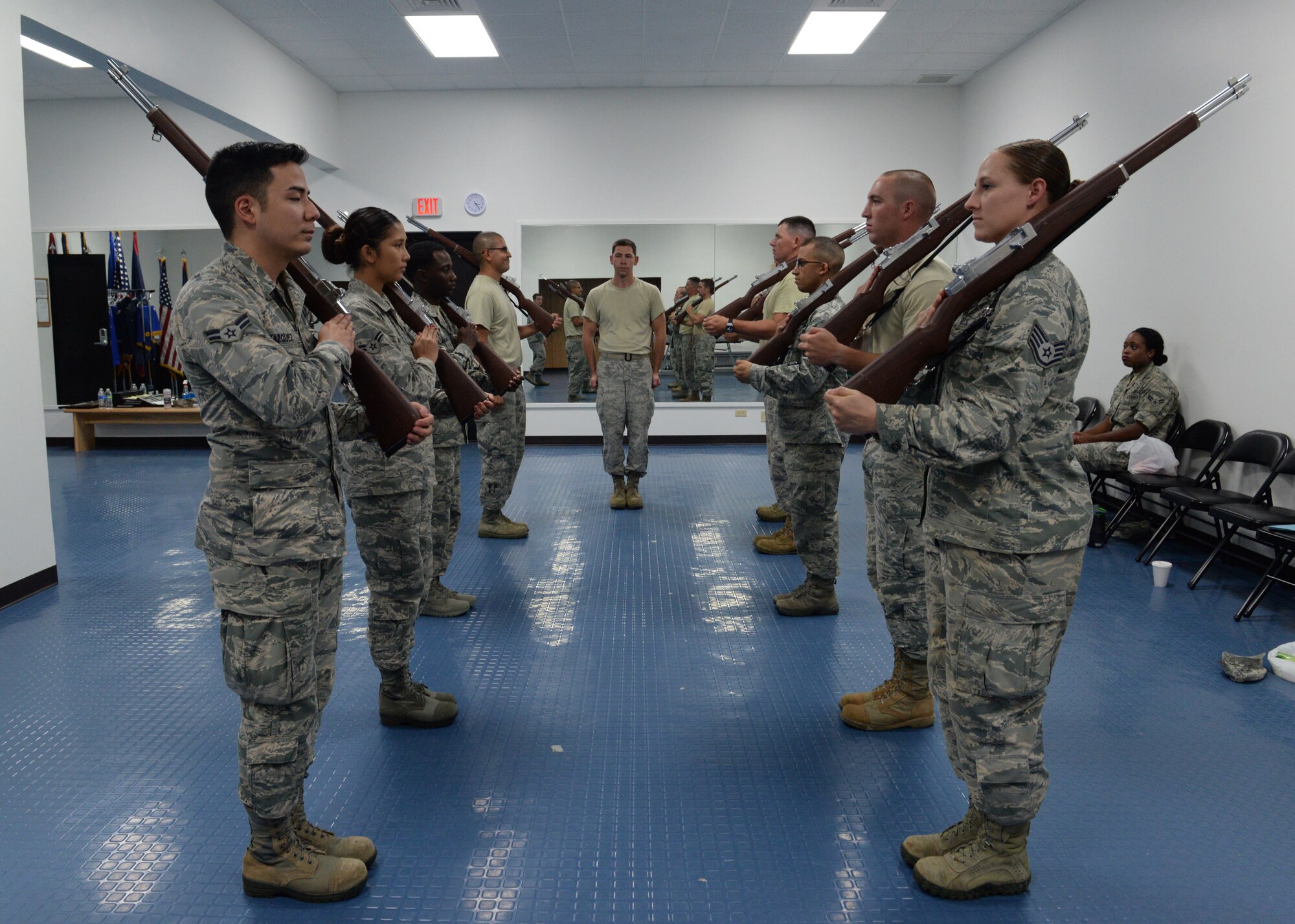 Senior Airman Patrick Duffie, a ceremonial guardsman from the 36th Operations Support Squadron, center, shouts commands while Andersen Blue Knights Honor Guard members practice weapons movements with training rifles June 24, 2015, at Andersen Air Force Base, Guam. Honor guard members follow strict guidelines while performing their duties to provide traditional military honors at ceremonies and funerals. (U.S. Air Force photo by Senior Airman Amanda Morris/Released)