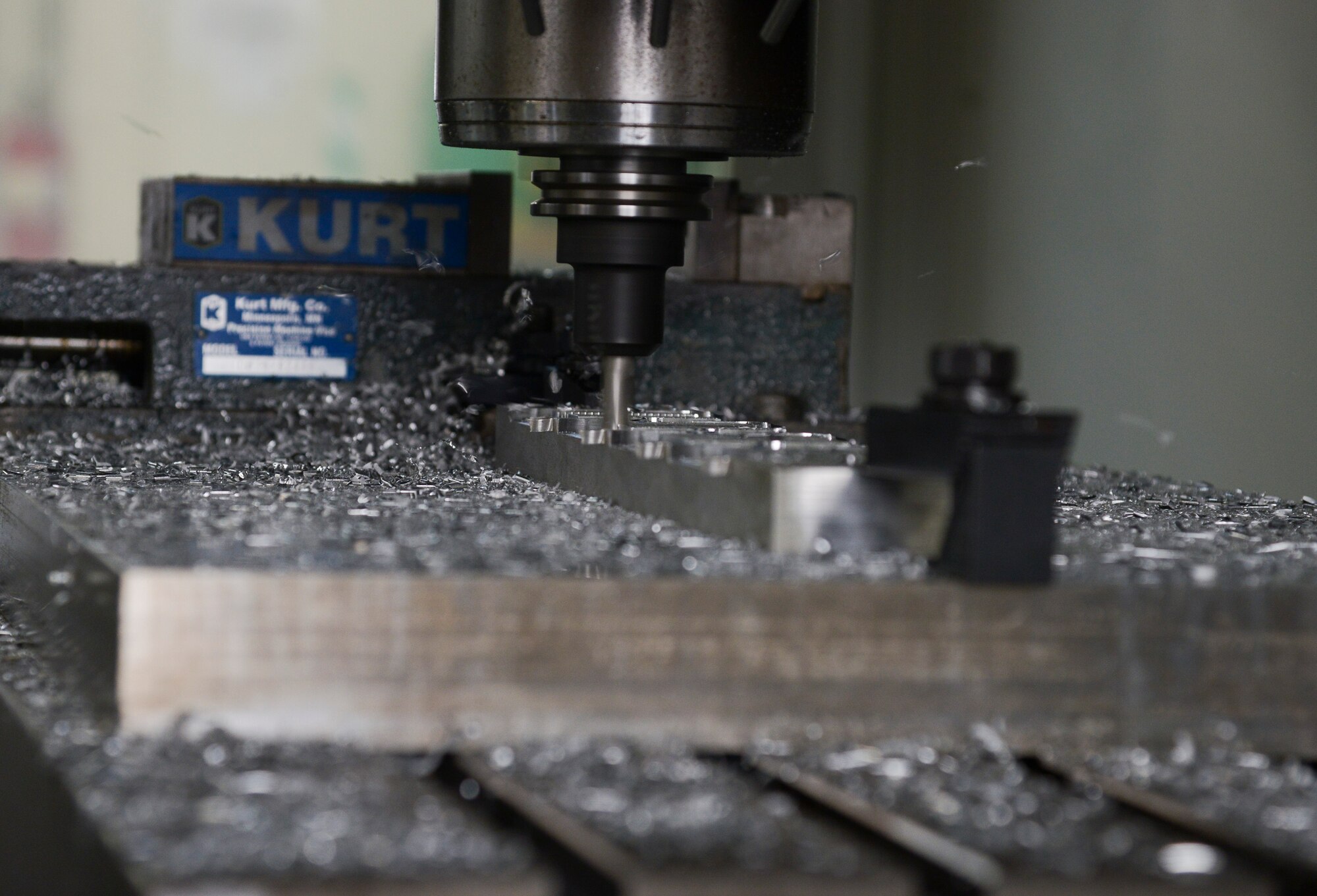A computer numeric controller router creates a C-130 Hercules crew door arm clamp in the fabrication shop at Yokota Air Base, Japan, June 23, 2015. A CNC router is a computer controlled cutting machine related to the hand held router used for cutting various hard materials, such as wood, composites, aluminium, steel, plastics and foams. (U.S. Air Force photo by Senior Airman David Owsianka/Released)