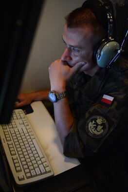 Lt. Pawel Nogalski, Polish Air Force ground control intercept weapons director, observes 115th Fighter Wing F-16 Fighting Falcons in the operations module at the 128th Air Control Squadron, Volk Field Air National Guard Base, Wisconsin, June 10, 2015. As part of the State Partnership Program, four service members from Poland spent their time in the United States working beside 128 ACS Airmen. (U.S. Air National Guard photo by Staff Sgt. Andrea F. Rhode)
