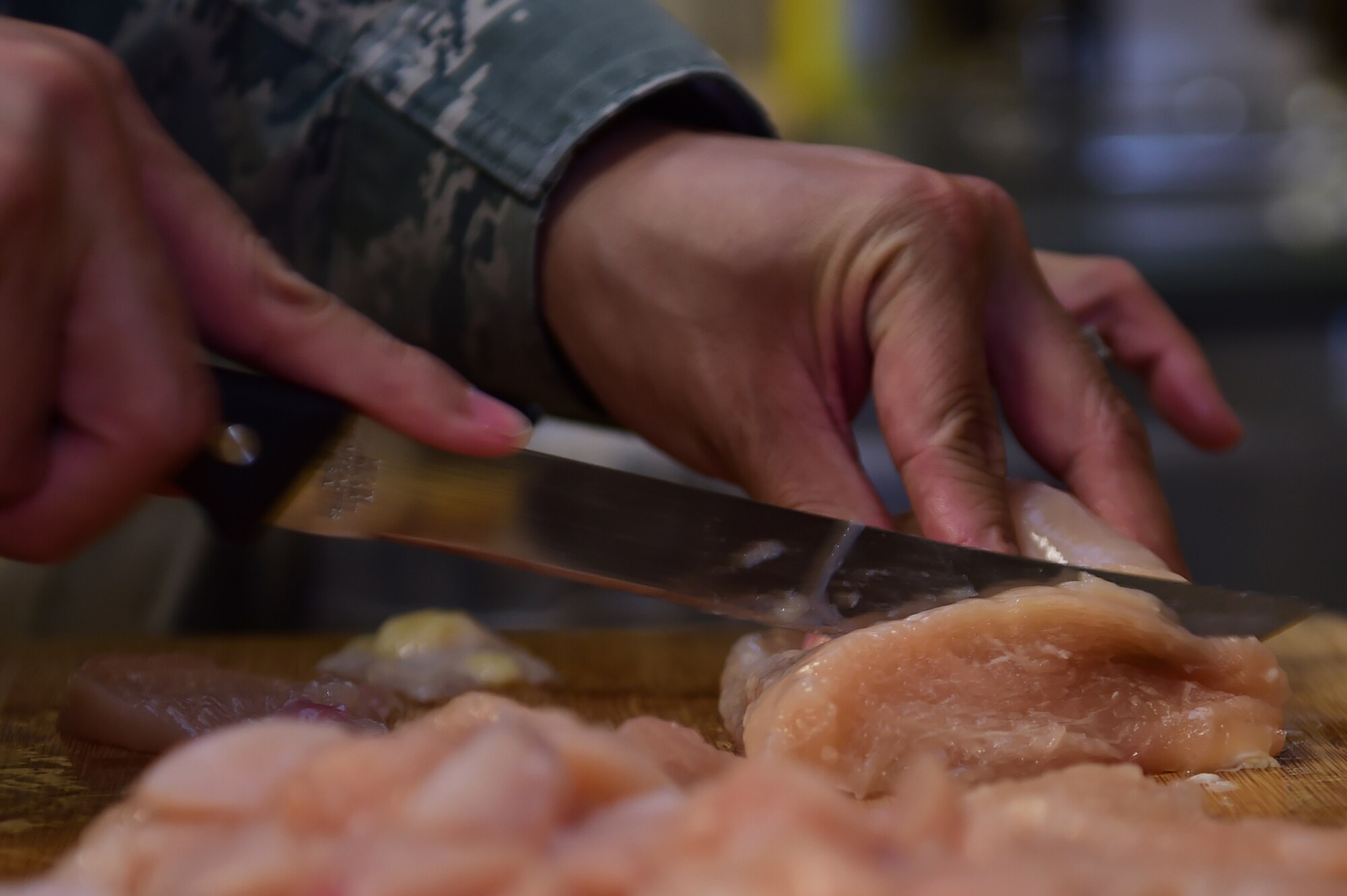 Tech. Sgt. Lee Smith, 460th Space Wing Equal Opportunity NCO in charge, prepares dinner for members of the Fisher House June 17, 2015, in Aurora, Colo. Team Buckley members volunteered at the Fisher House to show support for veterans and their families. (U.S. Air Force photo by Airman 1st Class Luke W. Nowakowski/Released)