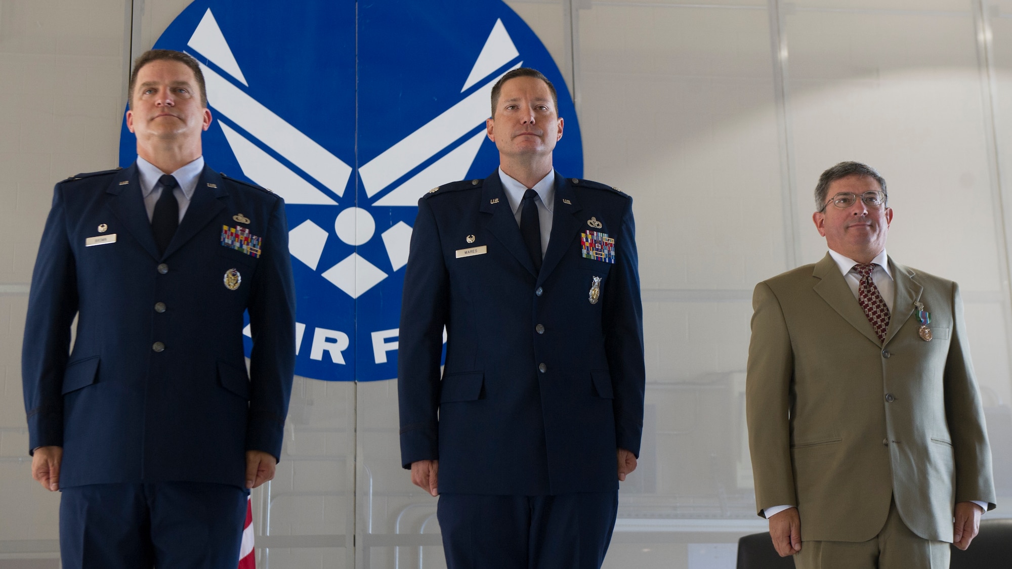 Colonel Greg Brown, 49th Mission Support Group commander, Lt. Col. Kevin Mares, incoming 49th Civil Engineer Squadron commander, and Aydin Budak, 49th CES outgoing commander, stand at attention after completing the Assumption of Command ceremony at Holloman Air Force Base, N.M., June 25, 2015. During the ceremony, Budak relinquished command to Mares. (U.S. Air Force photo by Airman 1st Class Emily A. Kenney/Released)