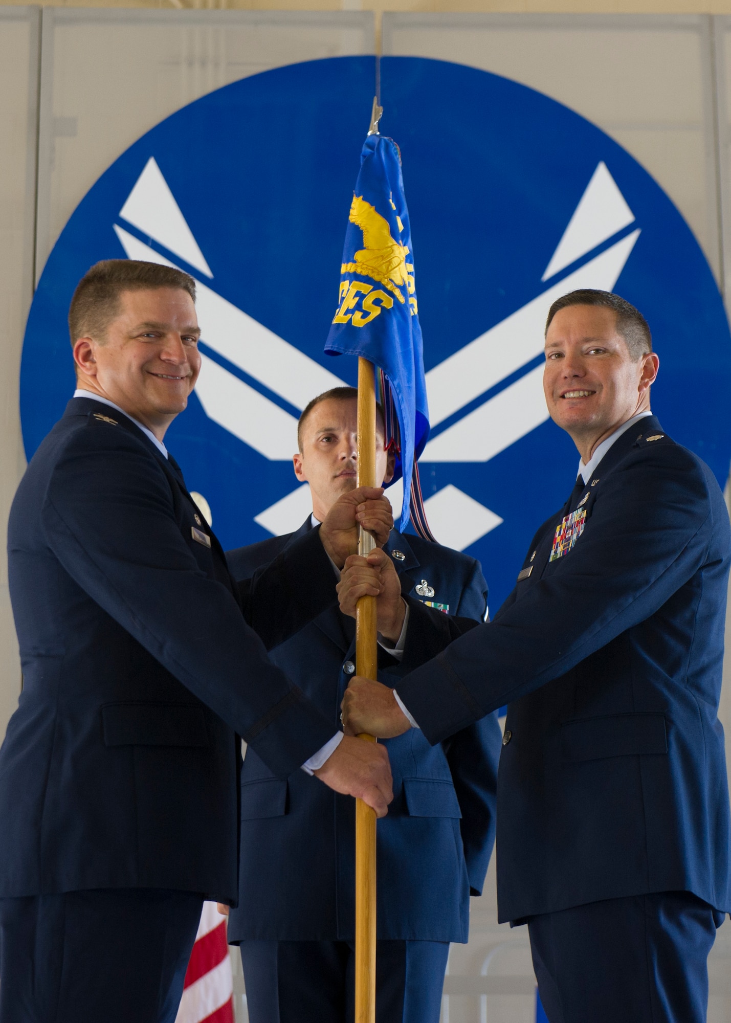Colonel Greg Brown, 49th Mission Support Group commander, and Lt. Col. Kevin Mares, incoming 49th Civil Engineer Squadron commander, pose for a photo with the 49th CES guidon during the CES Assumption of Command ceremony at Holloman Air Force Base, N.M., June 25, 2015. During the ceremony, Aydin Budak, acting commander of the 49th CES, relinquished command to Lt. Col. Kevin Mares. (U.S. Air Force photo by Airman 1st Class Emily A. Kenney/Released)