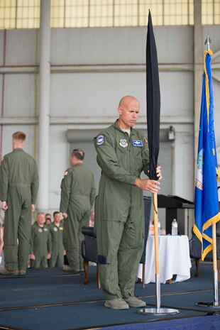 Chief Master Sgt. John Gallo places the retired 17th Airlift Squadron guidon flag back into the flag stand during the squadron's inactivation ceremony June 25, 2015 at Joint Base Charleston, S.C. As part of the President’s Defense Budget for FY15, one of Charleston’s four active-duty C-17 flying squadron's was designated for inactivation. In attendance at the ceremony were many of the squadron's former commander's including Maj. Gen. (ret) Ron Ladnier, who commanded the squadron when it stood up as the first operational C-17 squadron. Gallo is the 17th AS superintendent. (U.S. Air Force photo / Trisha Gallaway) 