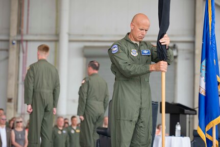 Chief Master Sgt. John Gallo places the retired 17th Airlift Squadron guidon flag back into the flag stand during the squadron's inactivation ceremony June 25, 2015 at Joint Base Charleston, S.C. As part of the President’s Defense Budget for FY15, one of Charleston’s four active-duty C-17 flying squadron's was designated for inactivation. In attendance at the ceremony were many of the squadron's former commander's including Maj. Gen. (ret) Ron Ladnier, who commanded the squadron when it stood up as the first operational C-17 squadron. Gallo is the 17th AS superintendent. (U.S. Air Force photo / Trisha Gallaway) 