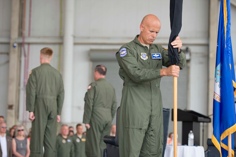 Chief Master Sgt. John Gallo places the retired 17th Airlift Squadron guidon flag back into the flag stand during the squadron's inactivation ceremony June 25, 2015 at Joint Base Charleston, S.C. As part of the President’s Defense Budget for FY15, one of Charleston’s four active-duty C-17 flying squadron's was designated for inactivation. In attendance at the ceremony were many of the squadron's former commander's including Maj. Gen. (ret) Ron Ladnier, who commanded the squadron when it stood up as the first operational C-17 squadron. Gallo is the 17th AS superintendent. (U.S. Air Force photo / Trisha Gallaway) 