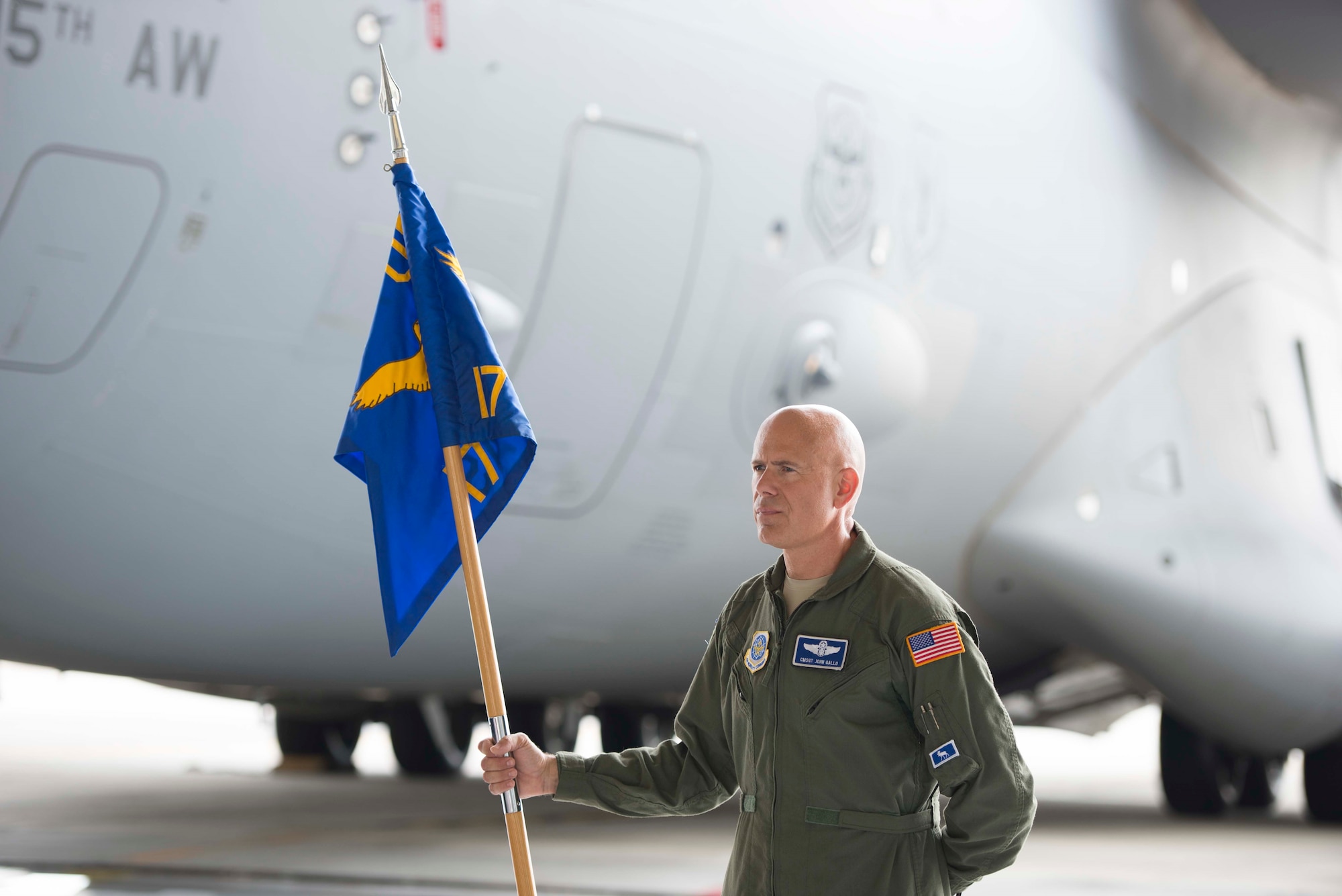 Chief Master Sgt. John Gallo bears the guidon during the 17th Airlift Squadron's inactivation ceremony June 25, 2015 at Joint Base Charleston, S.C. As part of the President’s Defense Budget for FY15, one of Charleston’s four active-duty C-17 flying squadron's was designated for inactivation. In attendance at the ceremony were many of the squadron's former commander's including Maj. Gen. (ret) Ron Ladnier, who commanded the squadron when it stood up as the first operational C-17 squadron. Gallo is the 17th AS superintendent. (U.S. Air Force photo / Trisha Gallaway)  