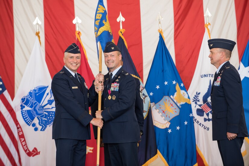 Col. James C. Hodges, former Joint Base McGuire-Dix-Lakehurst and 87th Air Base Wing commander, passes the 87th ABW guidon to Maj. Gen. Frederick H. Martin, U.S. Air Force Expeditionary Center commander, upon relinquishing command during a ceremony held June 25, 2015 at JB MDL, N.J. Hodges was selected for reassignment as the senior military assistant to the Assistant Secretary of the Air Force for Installations Environment and Energy in Washington, D.C.   He relinquished command to Col. Frederick D. Thaden. (U.S. Air Force photo by Russell Meseroll)