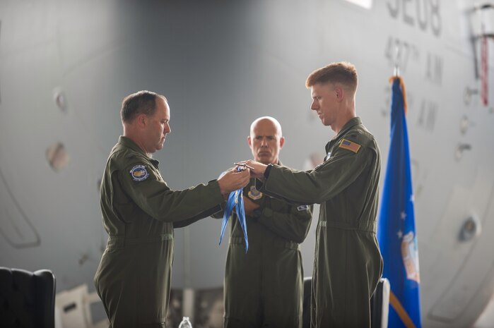 Col. Fred Boehm, 437th Operations Group Commander, and Lt. Col. Paul Theriot, 17th Airlift Squadron commander, roll up the squadron guidon during an inactivation ceremony for the 17th Airlift Squadron, June 25, 2015, at Joint Base Charleston, S.C. As part of the President’s Defense Budget for FY15, one of Charleston’s four active-duty C-17 flying squadron inactivated. The 17th AS was reactivated July 14, 1993 and was the first operational C-17 squadron. (U.S. Air Force photo/Senior Airman Jared Trimarchi) 