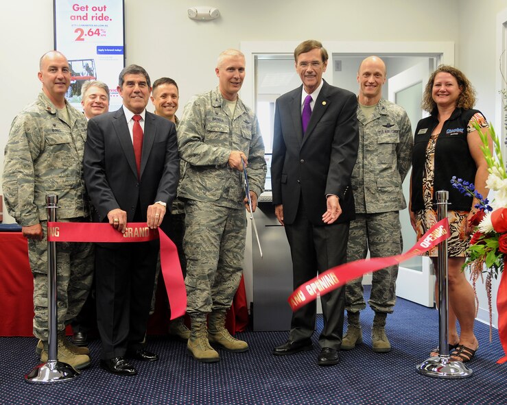 319th Air Base Wing leadership and Service Credit Union representatives pose for a ribbon cutting ceremony officiating the grand opening of the SCU branch on Grand Forks Air Force Base June 24, 2015.  The event took place in the newly refurbished facility for the SCU as they were previously based in a nearby temporary location. (U.S. Air Force Photo by Senior Airman Zachiah Roberson/released)