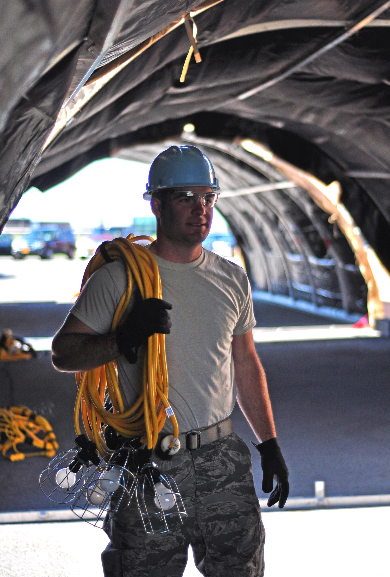 Senior Airman Colton Mattle, structural engineer, 914th Civil Engineer Squadron, prepares to hang lighting in at Niagara Falls Air Reserve Station, N.Y., on June 6, 2015. Mattle assists with preparation for weekend CES training exercises. (USAF photo by SSgt Richard D. Mekkri)  
