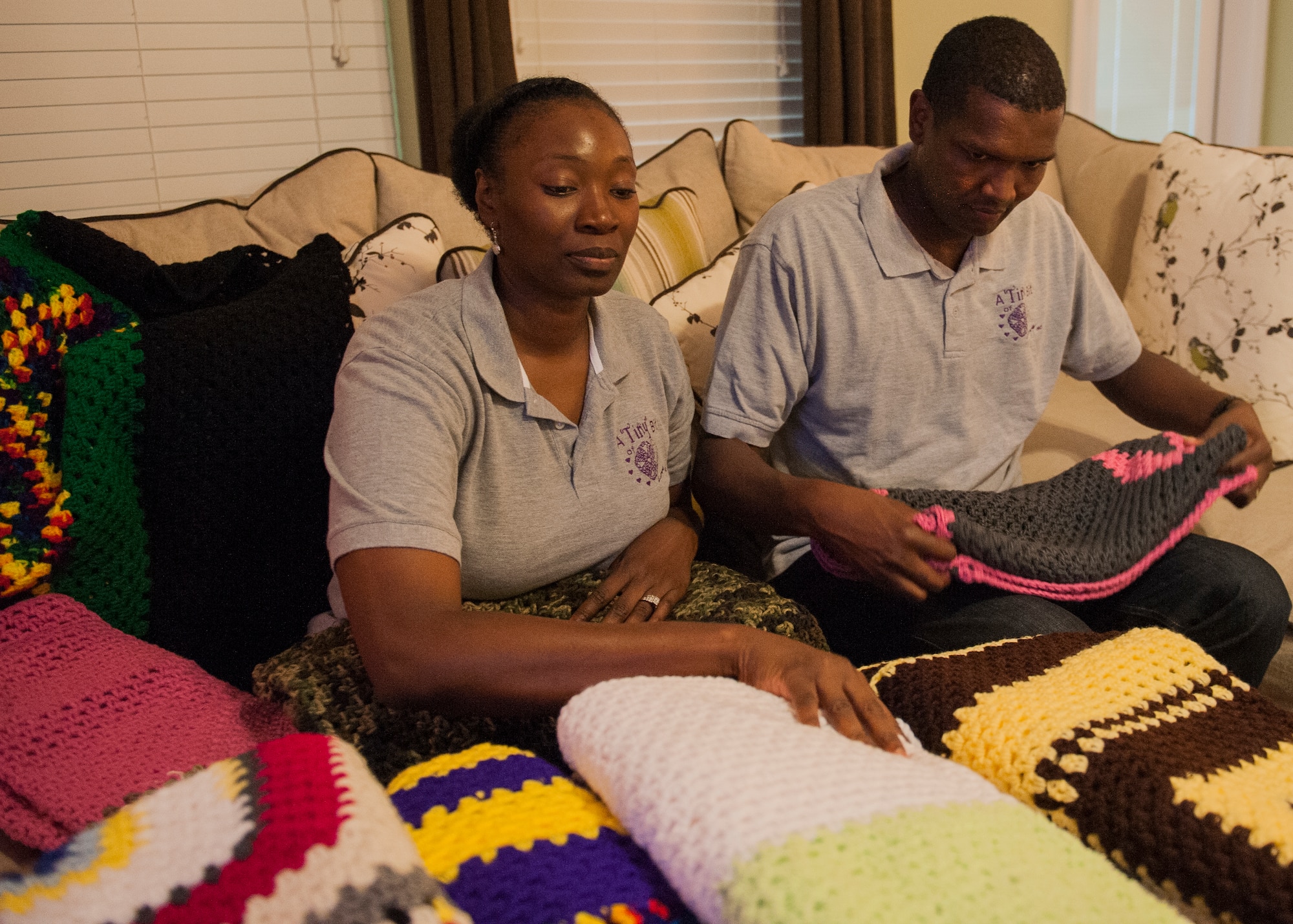 Tech. Sgt. Antonio Ruth, 33rd Fighter Wing and his wife, Master Sgt. Candace Ruth, 53rd Wing, take inventory of the blankets crocheted by Ruth June 10 near Eglin Air Force Base, Fla. Ruth formed an organization to honor his late mother, and  to continue her  legacy of caring and giving.  A “Tiny” Bit of Love provides handmade blankets to cancer patients. (U.S. Air Force photo/Ilka Cole)