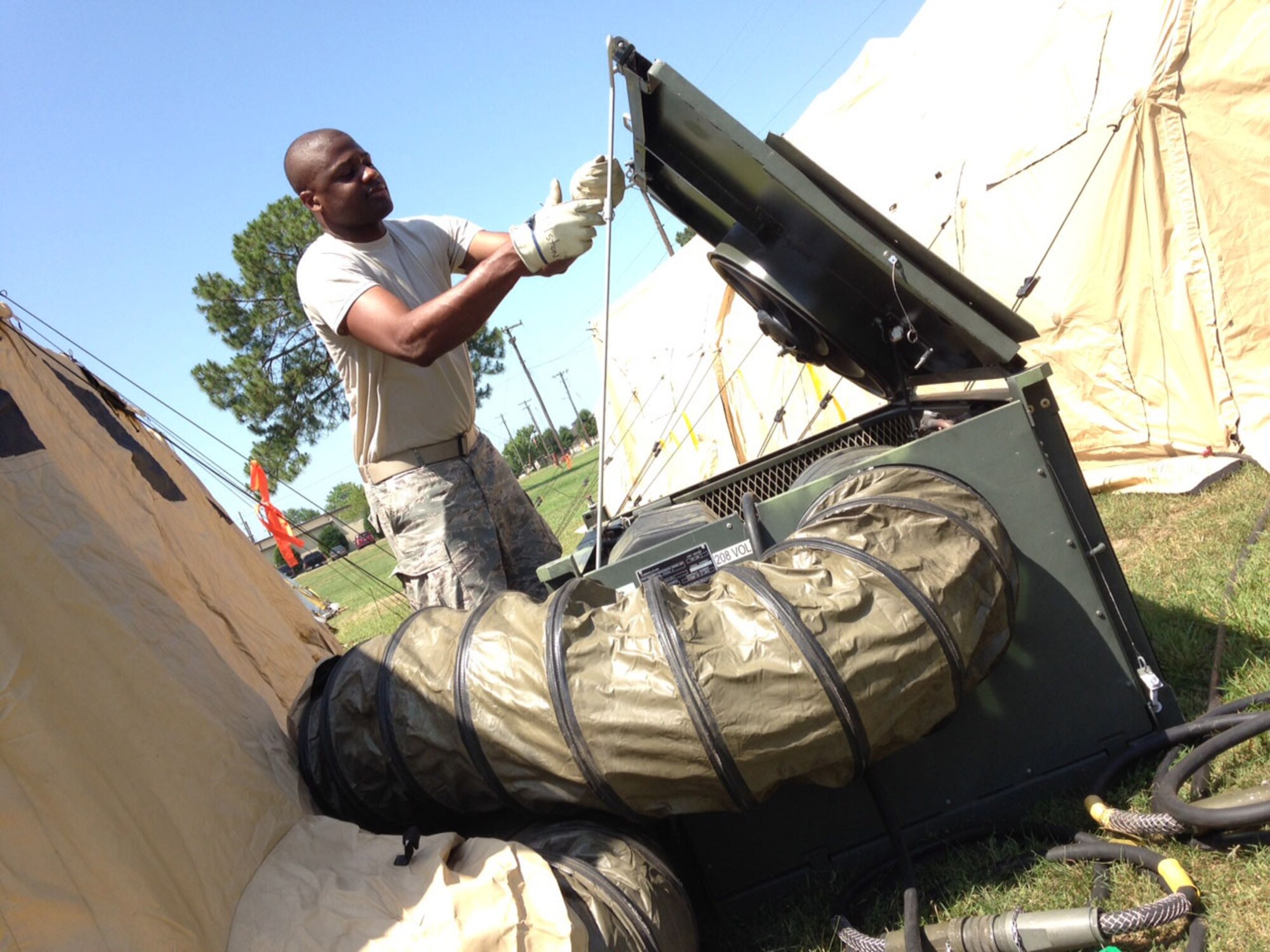 Technical Sgt. Ernest Holston of Sanford, a Heating Ventilation and Air Conditioning (HVAC) technician with the North Carolina Air National Guard's New London-based 263rd Combat Communications Squadron, monitors a critical air conditioning unit during exercise "Medusa Rising" at Seymour Johnson Air Force Base, Goldsboro, N.C. June 15, 2015. HVAC equipment not only cools the unit's people but also the sophisticated communications gear making it essential for mission success. (U.S. Air Force photo by Lt. Col. Robert Carver, North Carolina Air National Guard Public Affairs/Released)