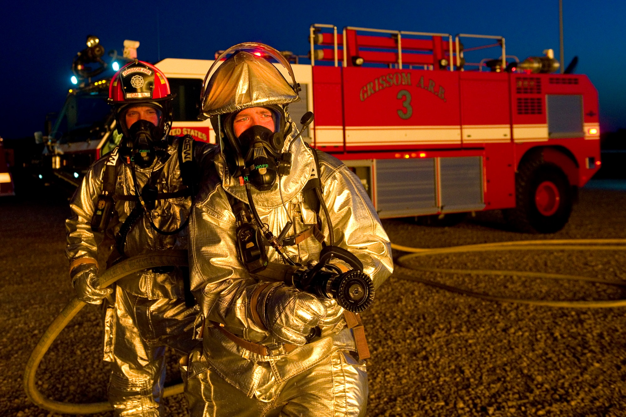 Jason Hofmeister, front, and Capt. Jason Cahill, both Grissom Fire Department firefighters, pose for a photo during a night-time training exercise at Grissom Air Reserve Base, Ind. May 21, 2015. The exercise allows firefighters to become accustomed to using their equipment in poor-visibility conditions. (U.S. Air Force photo/Tech. Sgt. Benjamin Mota)