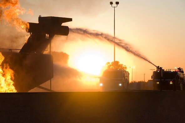 Grissom firefighters, operating two fire trucks, extinguish flames on a mock airframe during a night-time training exercise at Grissom Air Reserve Base, Ind., May 21, 2015. The fire department is one of several organizations at Grissom that work and train after dark and around the clock to ensure personnel and property are kept safe. (U.S. Air Force photo/Tech. Sgt. Benjamin Mota)